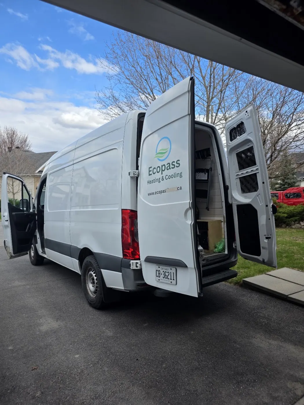 White service van with rear doors open on a residential street